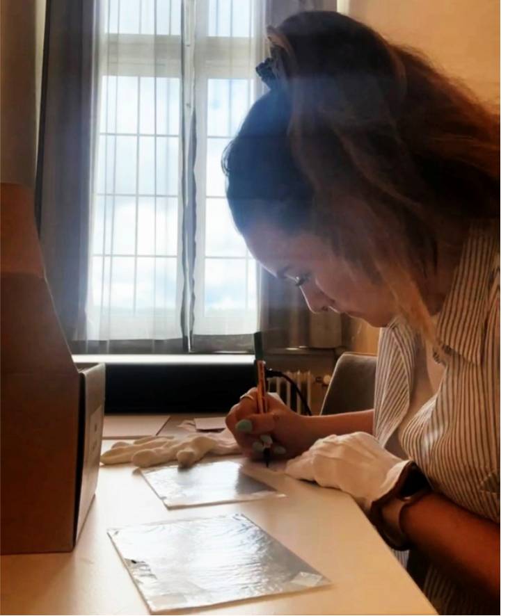 Meghan examining glass negatives at the Ellingen Residence.